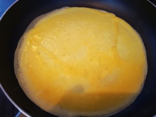 年味~树花菜蒸蛋卷,不粘平底锅烧热后倒入少许蛋液，持锅快速划圈摇均成薄蛋皮，凝固后翻面，煎熟即可取出，再做下一张蛋皮