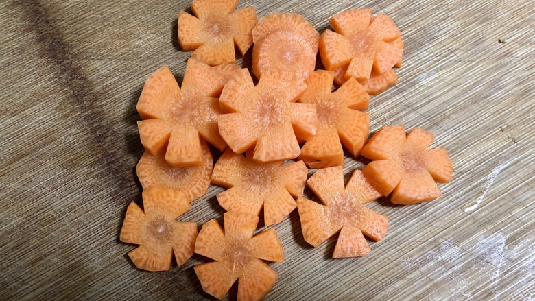 咖喱乌冬面,在胡萝卜片的边缘切掉小先三角，切成小花的形状，为了摆盘好看，不切也可以。