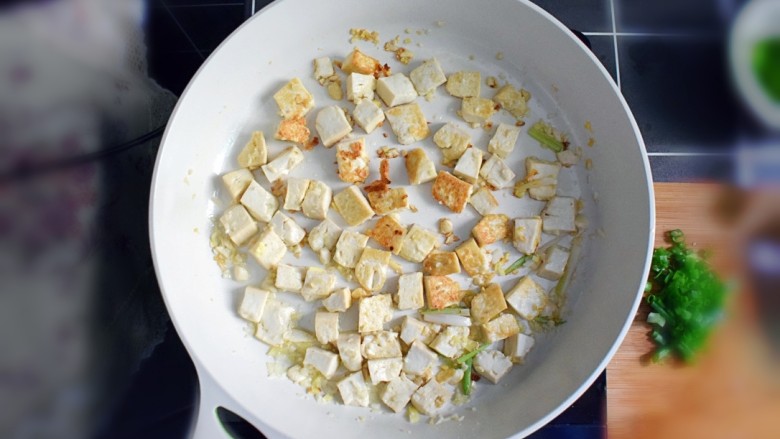 金钩海米炒豆腐,继续煎至豆腐呈金黄色。