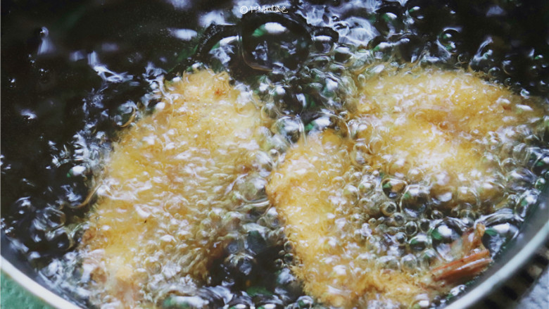 黄金蝴蝶虾,锅里放适量油，烧热后放入大虾炸至金黄色后捞出。