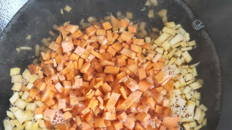 早餐必备的减肥餐------地瓜胡萝卜牛奶燕麦粥 ,倒入切好的地瓜丁和胡萝卜丁，煮3-4分钟