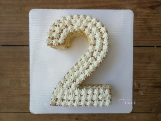 数字蛋糕,盖上第3片数字蛋糕片，在表面均匀地挤满小奶油花