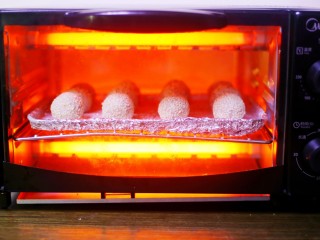 奶香芋泥芝麻球,放入提前预热的烤箱中，上下火170℃烤30分钟。
