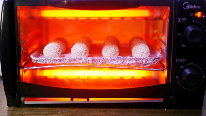 奶香芋泥芝麻球,放入提前预热的烤箱中，上下火170℃烤30分钟。