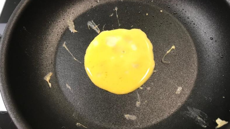 《过年应景-黄金蛋饺》,放上蛋液后用汤匙的背面抹匀
👉记得一定要用最小火哦！蛋液才不会马上熟
*一颗蛋饺的蛋量约一隻汤匙🥄