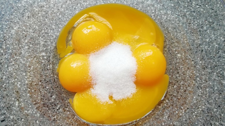斑马纹戚风蛋糕(8寸),给蛋黄里面加入15g细砂糖，用手动打蛋器搅打均匀。