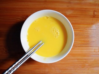 海米韭菜鸡蛋水饺,将鸡蛋打入碗中，用筷子搅拌均匀。