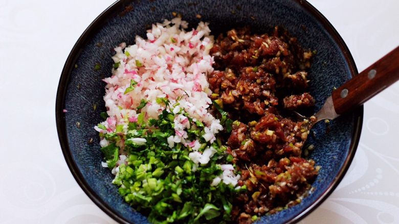 長長久久的翡翠白玉牛肉蘿蔔餃子,把水蘿蔔和香菜末倒入攪拌好的牛肉