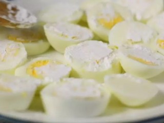 年夜饭必备的一道菜, 做法简单的“金钱蛋”, 保准家人都爱吃,煮好的鸡蛋过冷水，剥去蛋壳，鸡蛋切厚片，两面撒上淀粉