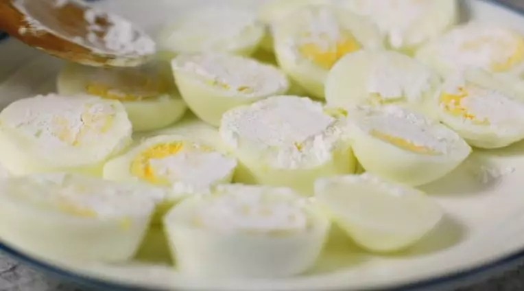 年夜饭必备的一道菜, 做法简单的“金钱蛋”, 保准家人都爱吃,煮好的鸡蛋过冷水，剥去蛋壳，鸡蛋切厚片，两面撒上淀粉