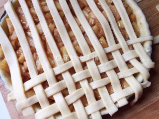 肉桂苹果派,在派盘表面编织成交叉的网，编好后，同样要把多余的派皮切断