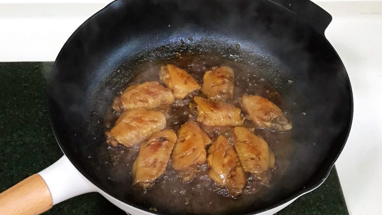 蜜汁鸡翅,盖上锅盖，中火焖炖15分钟，炖好后，开大火收汁，完全收干，让酱汁在鸡翅上挂住。