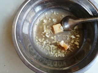 腐乳花生焖猪手,碗里装入剁好的蒜蓉、腐乳、腐乳汁和一小半碗水，用汤匙将腐乳压烂并拌均匀