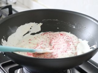 草莓牛轧糖，酸甜美味新年糖,完全融合后，倒入草莓奶粉，快速压拌匀，不见奶粉，关火。