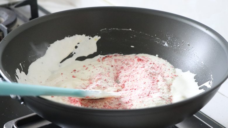 草莓牛轧糖，酸甜美味新年糖,完全融合后，倒入草莓奶粉，快速压拌匀，不见奶粉，关火。