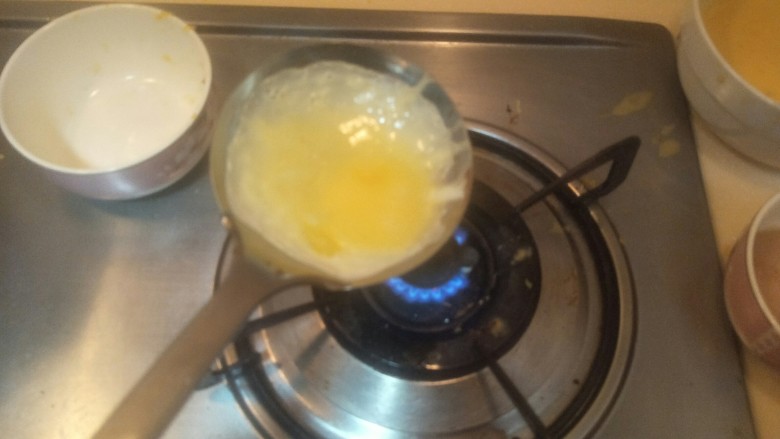 “金元宝”蛋饺,继续晃动。一定要涂满猪油，看到蛋皮边缘开始凝结了。