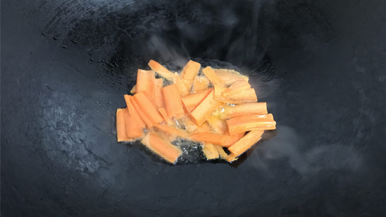 百合荷兰豆,锅中倒入适量油，6成热，放入胡萝卜片翻炒。
