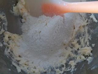 巧克力豆曲奇,把低筋面粉过筛到黄油霜内，用硅胶刮刀拌均匀。