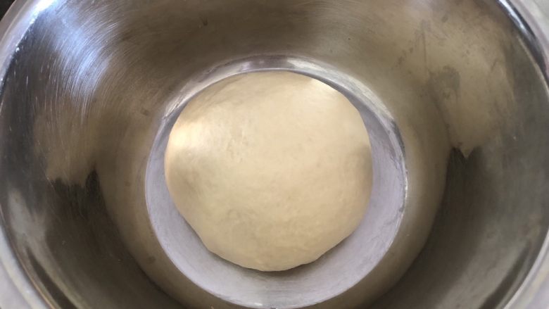 椰蓉餐包,揉成光滑面团取出，表面覆盖保鲜膜静置发酵