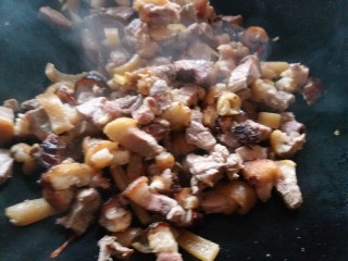 炖腊猪蹄,6.再把肉放进锅里爆炒，加入一勺料酒，两勺生，翻炒均匀。