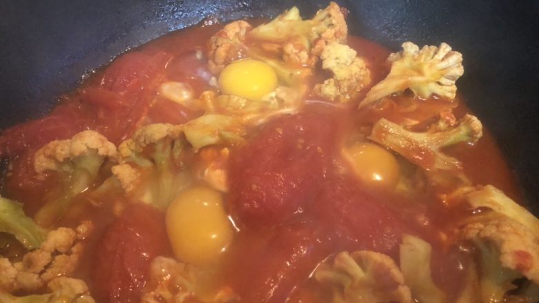 红火新年菜之番茄花菜焗蛋,煮开后开盖，转小火，敲入三个鸡蛋。