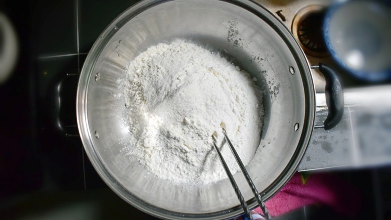 奶香葡萄干小面包（电饭锅版）,将面粉倒入一个大的容器中。