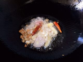 烧黄花鱼,放入毛葱、生姜、大蒜、红辣椒爆香