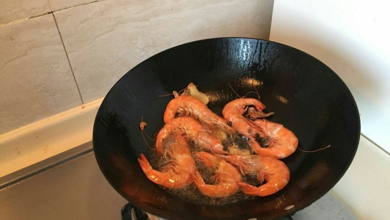 脆壳油爆大虾,继续把虾翻面背面沿边炒到金黄。要煸炒到虾壳变脆。