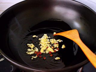 茼蒿海虾木耳小炒,热锅倒入花生油烧热后放入花椒先小火炒出香味后，再放入大蒜末爆出香味。
