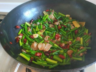 麻辣爆炒蒜苔，新文美食,加入适量盐，鸡精，炒均匀即可出锅。