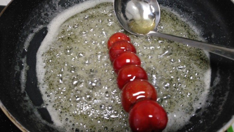 冰糖葫芦,把穿好的山楂，放入锅中，均匀浇上糖稀。