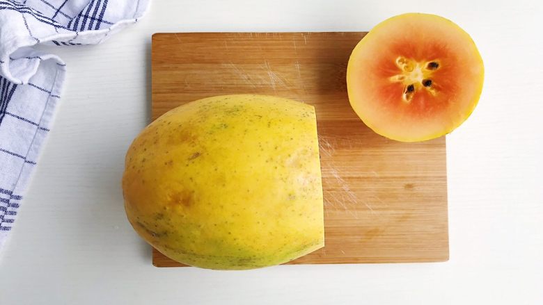 木瓜椰奶冻,食材处理（二）：

取一个木瓜 头部两三厘米左右切开
（挑选一个成熟度刚刚好的木瓜 太生的肉质坚硬 太成熟的软榻不成形）