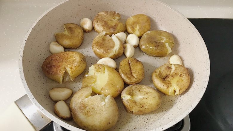 椒盐土豆仔,趁热用勺子或者铲子将小土豆稍微压扁