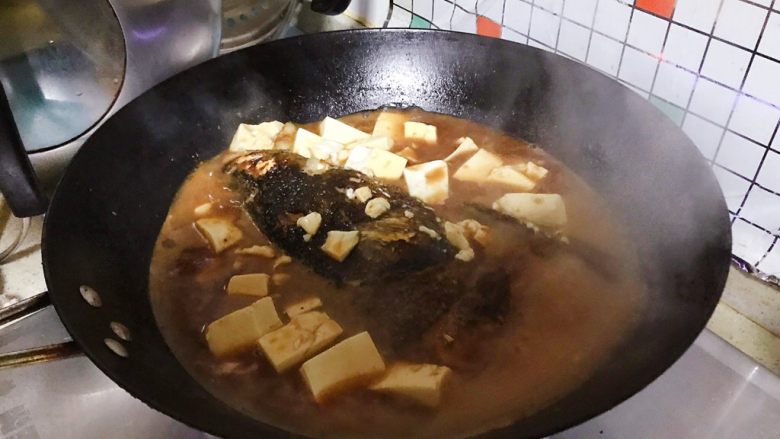 豆瓣酱千岛湖鱼头豆腐,15分钟后，把鱼头翻个身，再加入豆腐，然后盖上锅盖继续煮15-20分钟