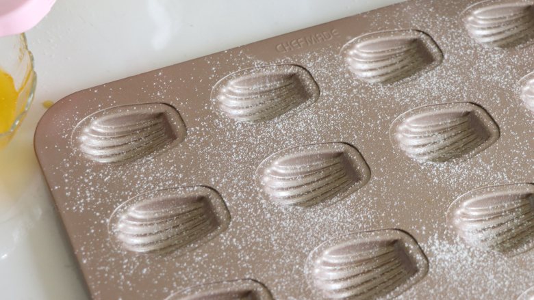 巧克力玛德琳,模具用少量的黄油涂抹一层，并撒一些薄薄的高筋面粉。