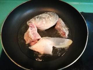 砂锅鱼头豆腐煲,油温八成热时，放入裹了生粉的鱼头块