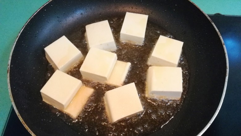 砂锅鱼头豆腐煲,接着把切好的豆腐放进锅里煎