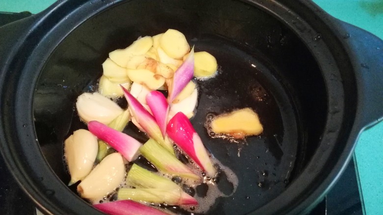砂锅鱼头豆腐煲,这时准备一个砂锅，锅里放少许油，放入切好的姜片，蒜瓣，葱白