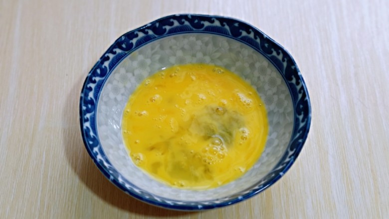 简单快手小零食～黑芝麻椰香吐司条,鸡蛋打入碗中，用筷子打散。