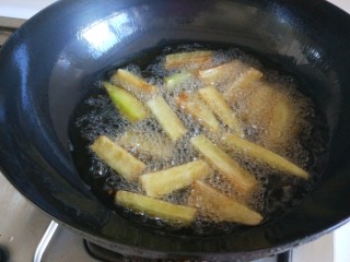 鱼香茄子  新文美食,锅中倒油烧七成热倒入茄子条。