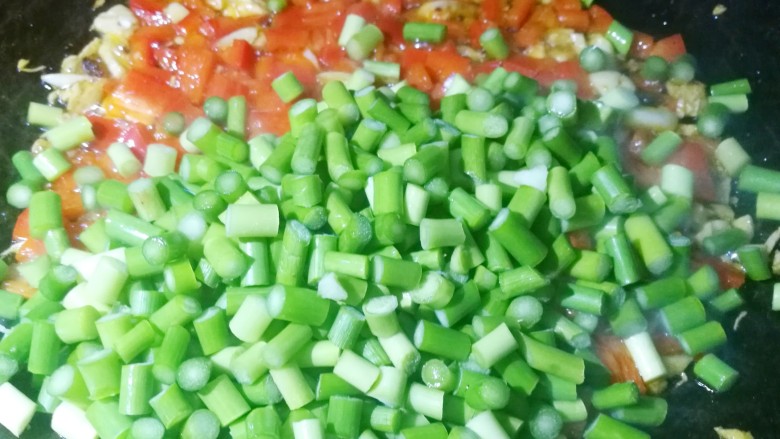超下饭神器蒜苔香干粒,加入蒜苔粒翻炒至变色。