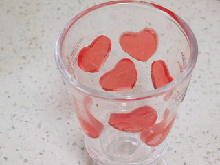 爱心满满滴~【草莓酸奶慕斯杯】,将爱心贴在杯壁上，用手指轻轻按压出空气
