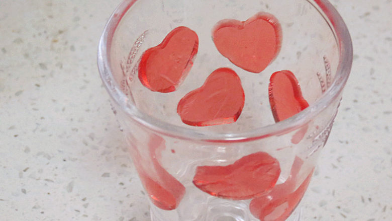 爱心满满滴~【草莓酸奶慕斯杯】,将爱心贴在杯壁上，用手指轻轻按压出空气