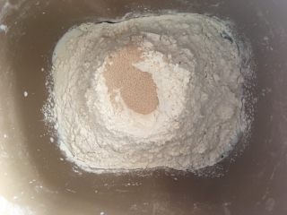 布里欧修面包,随后倒入面包粉，挖小窝倒入酵母粉埋起来
