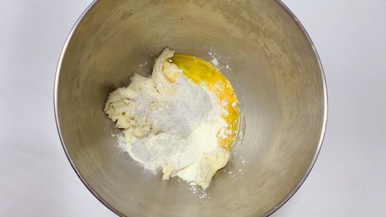 鸡蛋面包,冷藏发酵过后的中种面团撕成小块后放入面桶中，并加入主面团中除<a style='color:red;display:inline-block;' href='/shicai/ 887'>黄油</a>以外的所有材料揉成光滑面团