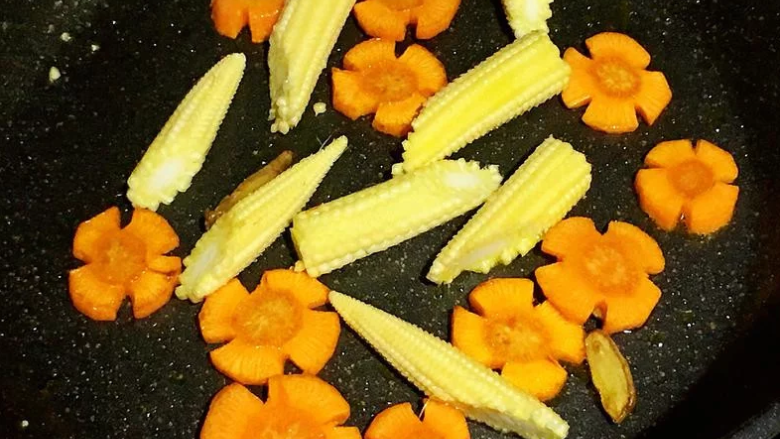 鲜蔬粉丝煲,放入玉米笋拌炒。
