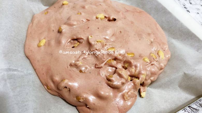 粉色蓝莓牛轧糖,最后准备一个烤盘，铺上油纸，把糖倒出来在油纸上整形，用折叠的方式把所有的材料都混合均匀
