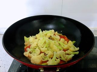茄汁花菜,放入焯好水的菜花，翻炒几下，放入盐、黑胡椒调味，撒上葱花。