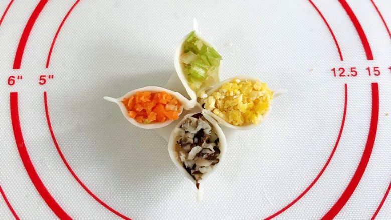 四喜蒸饺,依次填入香菇、胡萝卜、芹菜和鸡蛋，然后捏出个尖角。