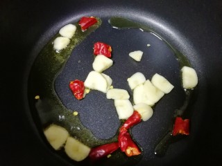 荷兰豆小炒,锅内倒油烧热，下入蒜片和干红辣椒炒香。